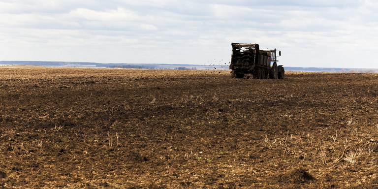 Tractor spreading manure over field