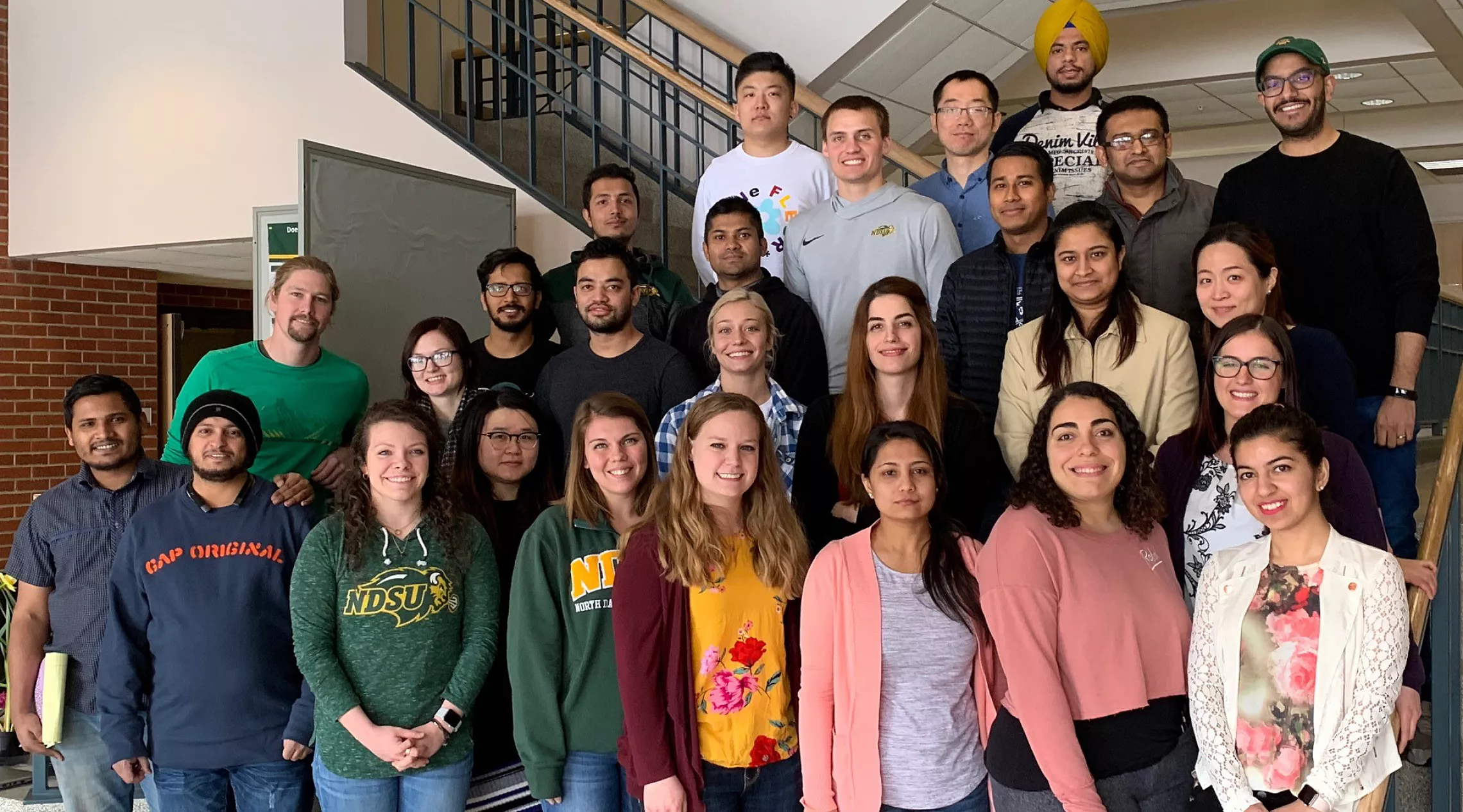 Students of Plant Pathology at NDSU posing by a staircase