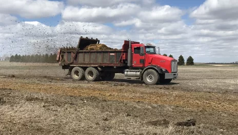 A truck-mounted horizontal spreader applies manure to a field at the NDSU Carrington Research Extension Center. 