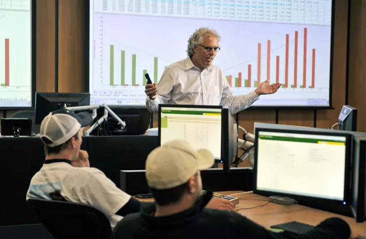 Professor talking in front of a presentation and students