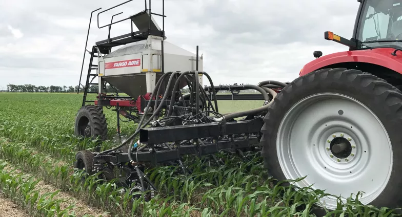 red tractor in field with cover crops