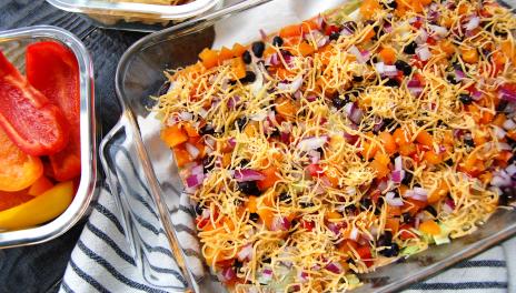 Layered Taco Dip, prepared and in a glass serving pan