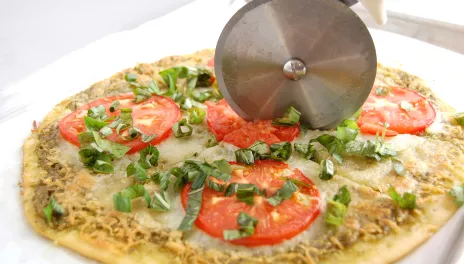 Margherita Pizza, fully cooked and being cut into slices