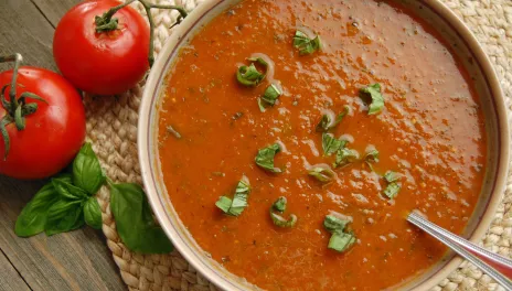 Rustic Tomato Basil Soup, prepared and served in a bowl with basil leaves on top