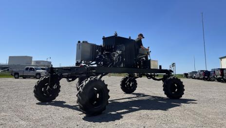 Man sits on top of robotic vehicle. 