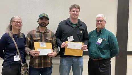 Four people holding an award