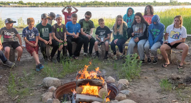 4H camp kids sitting around campfire