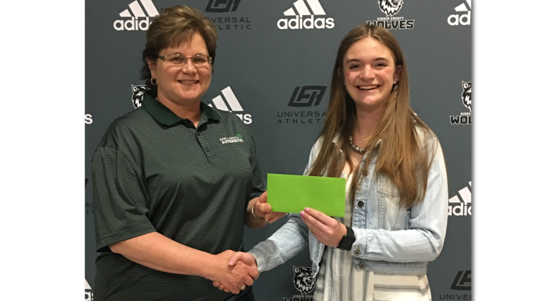 woman presenting a scholarship to a 4-H'er