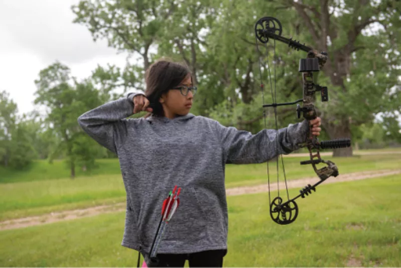 Native American girl with bow drawn