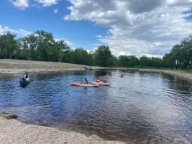 kids kayaking on a pond